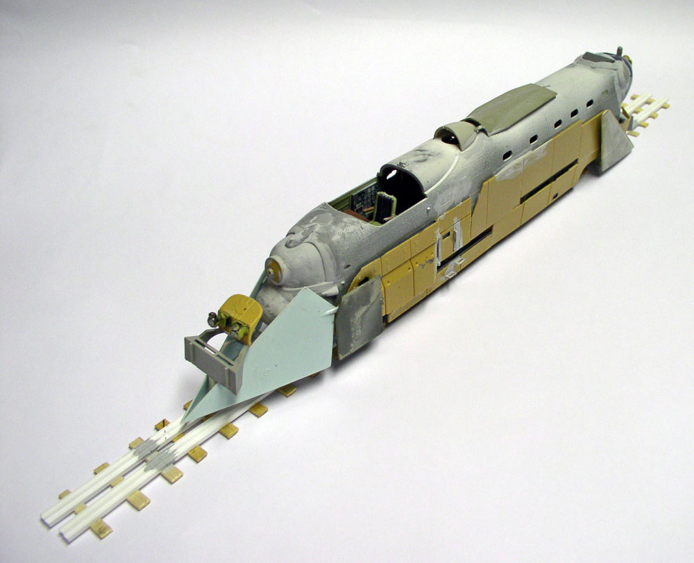 Maquette de train blindé allemand gris et sable sur rails, avec chasse-pierres avant et habitacle ouvert