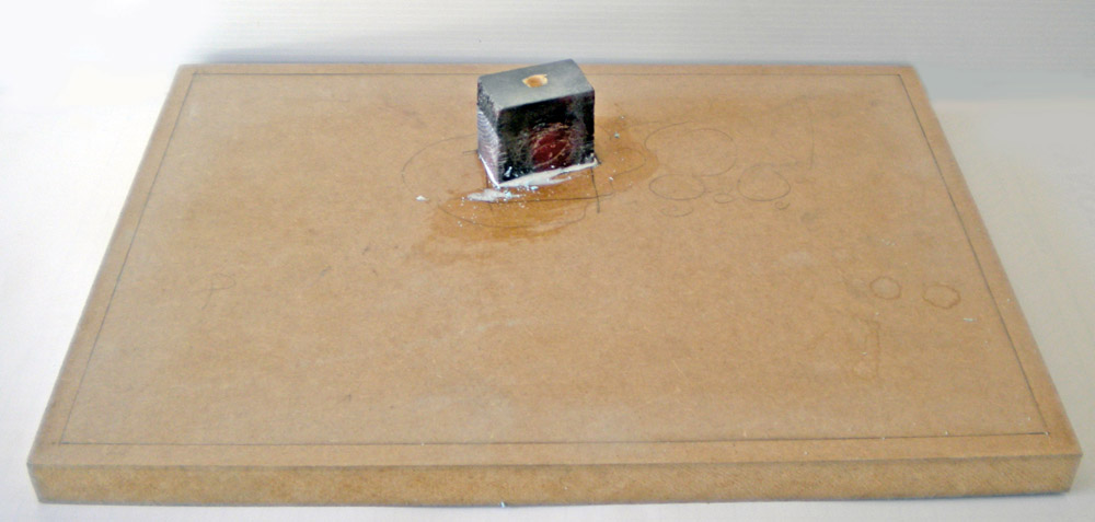 Petit bloc de résine gris collé sur une planche de bois pour maquette