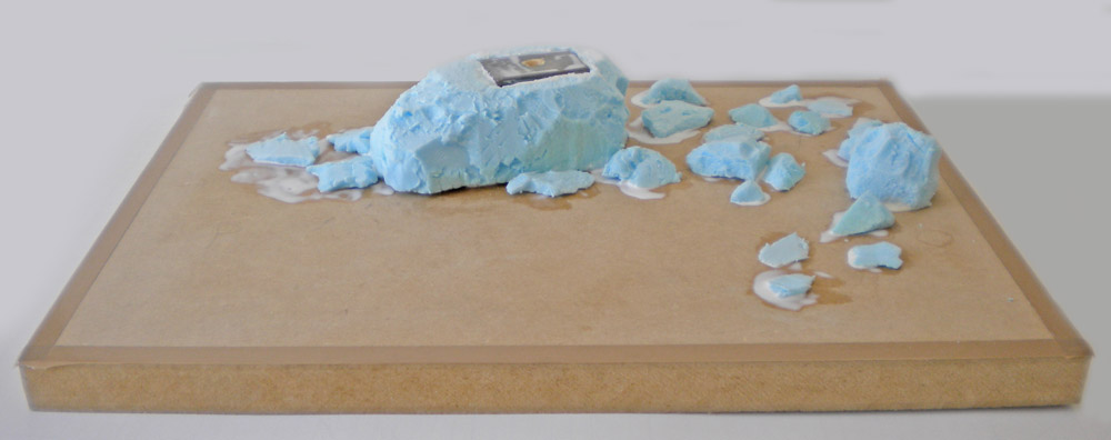 Bloc de mousse bleue sculptée et morceaux découpés sur un socle en bois
