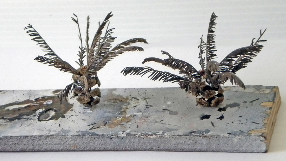 Deux maquettes de plantes type fougères réalisées sur un socle gris texturé