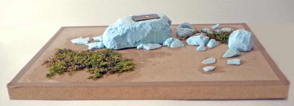 Maquette en cours avec rochers en mousse polystyrène bleue et mousse végétale sur socle