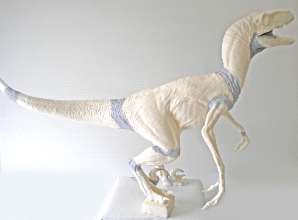 Maquette de velociraptor non peinte, gueule ouverte, montée sur socle avant mise en peinture