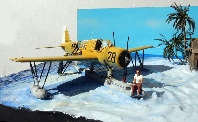 Maquette d'hydravion Vought OS2U Kingfisher jaune numéro 28 sur diorama de plage tropicale avec palmiers