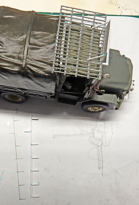 Maquette de camion militaire M35A2 bâché kaki avec structure grillagée sur la cabine, posée sur plans de montage