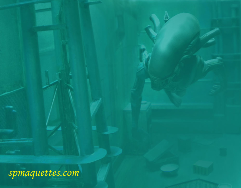 Maquette d'Aqualien xénomorphe flottant dans un décor industriel sous-marin aux teintes vert-bleu