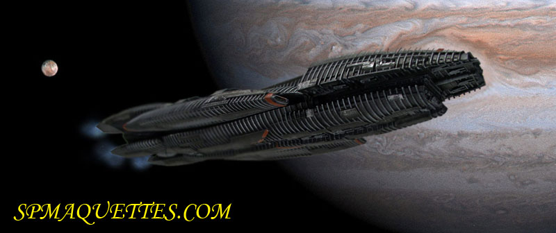Maquette du vaisseau Battlestar Galactica devant la planète Jupiter et une lune