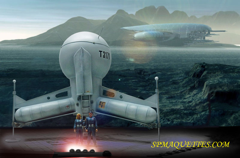 Maquette du G.N.U. T317 posée sur un sol extraterrestre, deux pionniers devant et vaisseau au loin