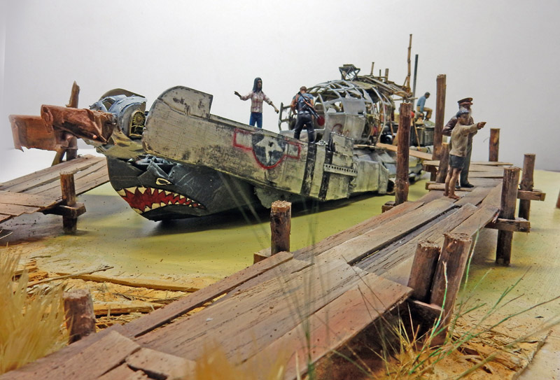 Bateau construit à partir d'une épave d'avion à dents de requin, amarré près de pontons en bois