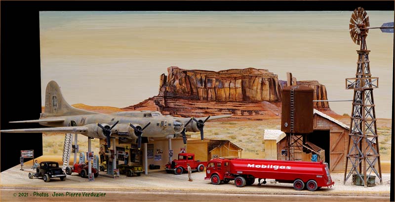 Diorama d'une station-service avec avion quadrimoteur, camion-citerne Mobilgas et éolienne devant un décor désertique