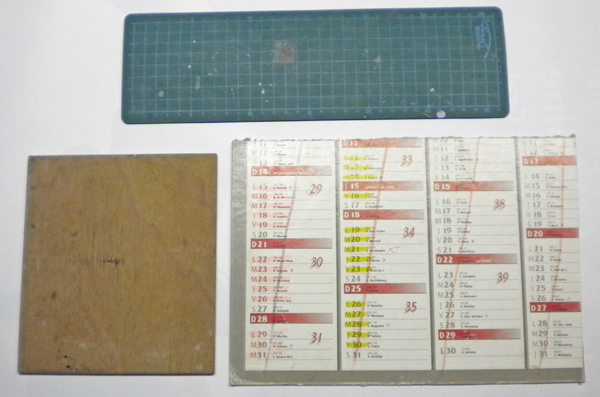 Tapis de découpe, planchette de ponçage et calendrier servant de surfaces de travail pour le maquettisme